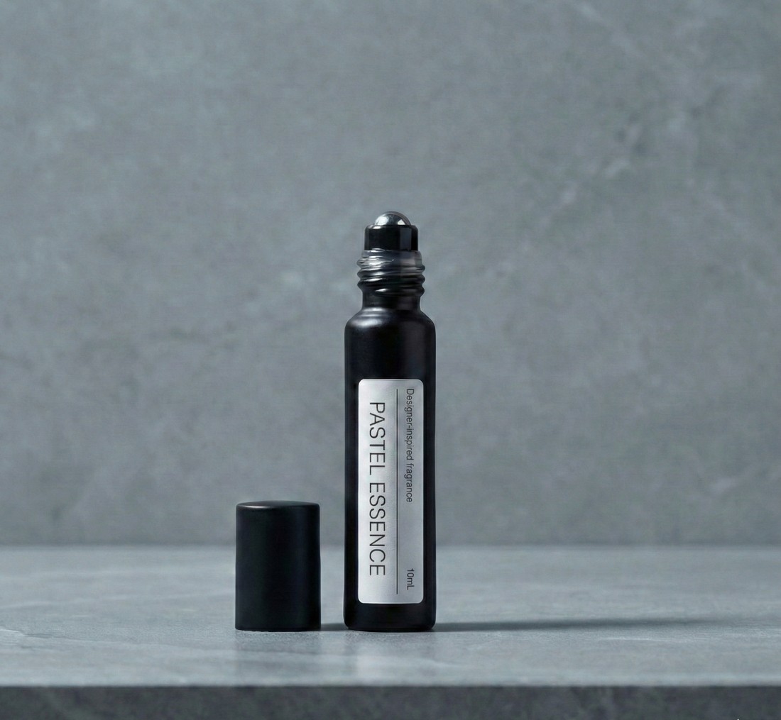 Close up of a luxury glass perfume roll-on bottle representing the best Chanel Chance Eau Tendre dupe next to fresh grapefruit and pink rose petals.